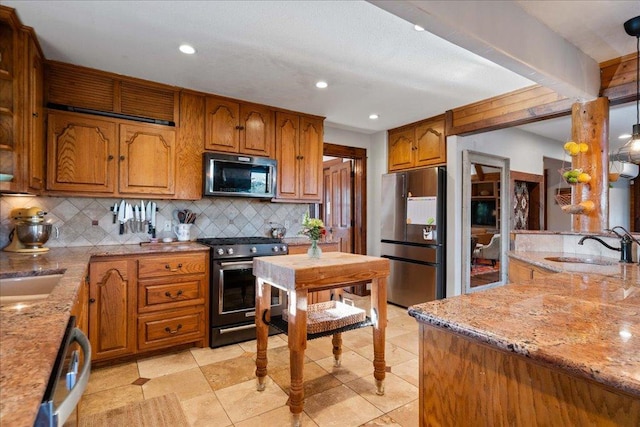 19801 Adrian Way, Jonestown, TX 78645 - kitchen with appliances with stainless steel finishes, a sink, decorative backsplash, brown cabinets, and light stone counters