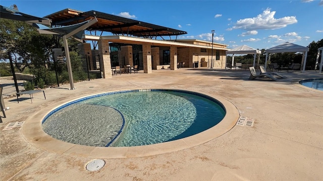 pool with a gazebo and a patio area