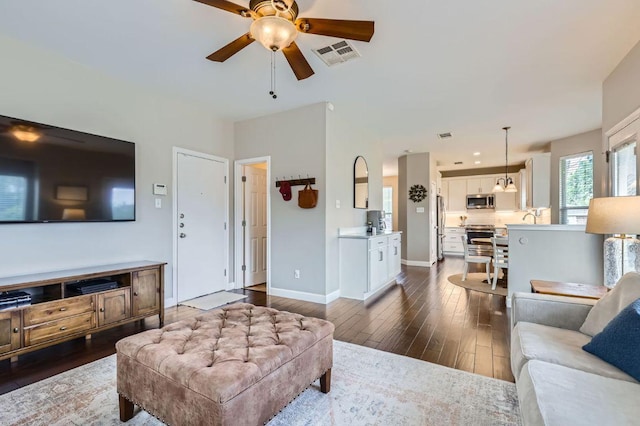 2106 Valerian Trl, Round Rock, TX 78665 - living room featuring a ceiling fan, dark wood-style floors, and baseboards