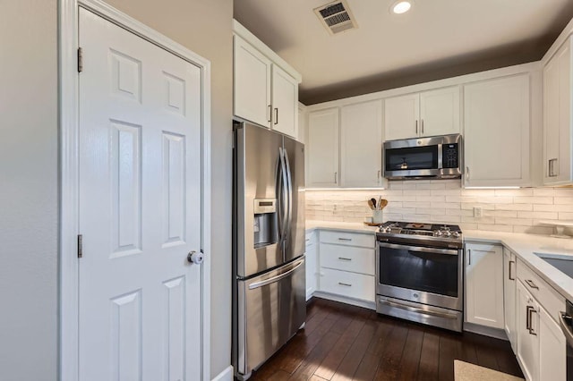 2106 Valerian Trl, Round Rock, TX 78665 - kitchen featuring stainless steel appliances, light countertops, dark wood-type flooring, decorative backsplash, and recessed lighting