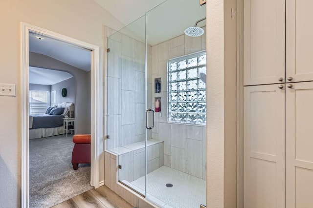 2106 Valerian Trl, Round Rock, TX 78665 - ensuite bathroom featuring a stall shower, vaulted ceiling, plenty of natural light, and wood finished floors
