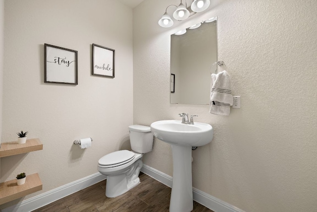 1051 Kenney Fort Xing Unit 73, Round Rock, TX 78665 - bathroom featuring toilet, wood finished floors, baseboards, and a sink