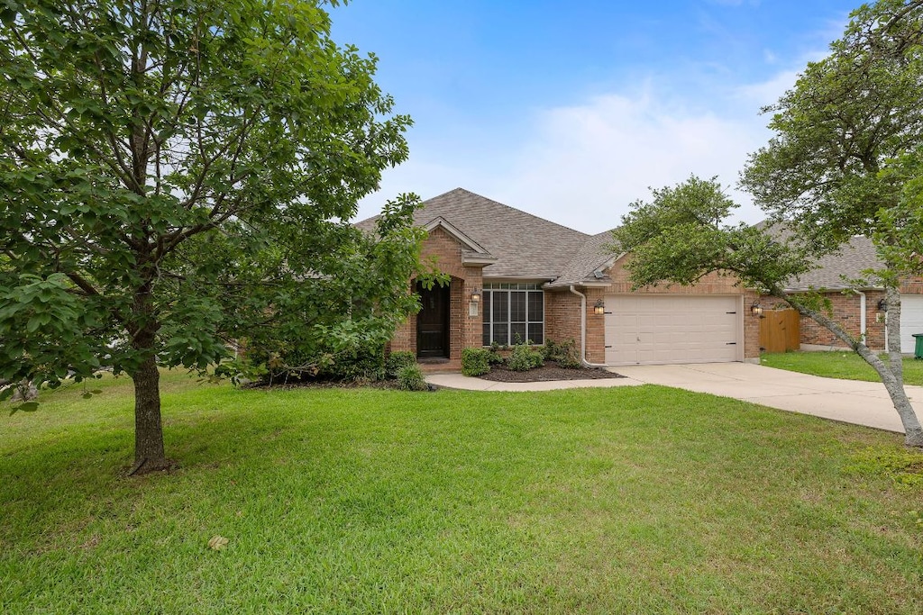 11200 Ladera Vista Dr, Austin, TX 78759 - view of front of property featuring brick siding, concrete driveway, an attached garage, a shingled roof, and a front yard