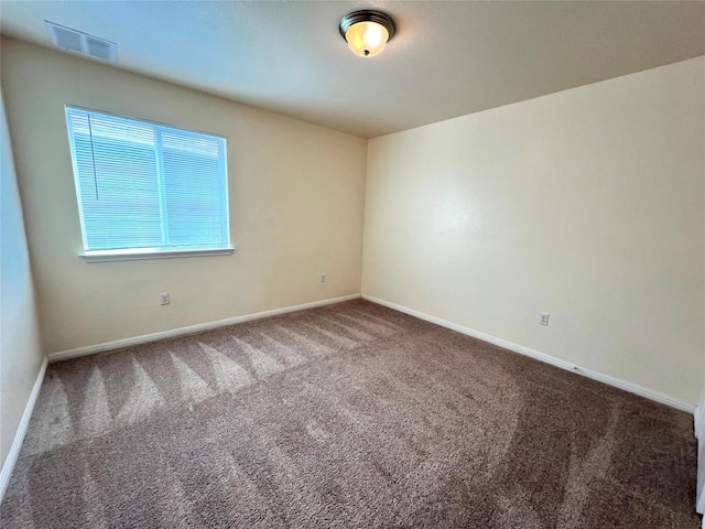 carpeted spare room with visible vents and baseboards