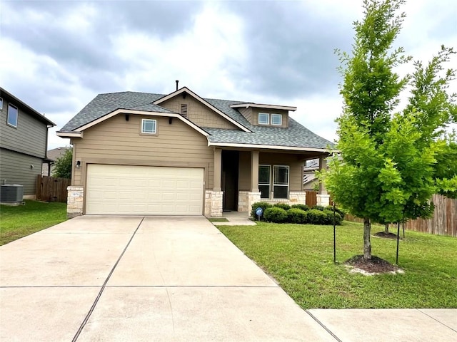 craftsman-style house featuring fence, central AC unit, driveway, stone siding, and a front lawn