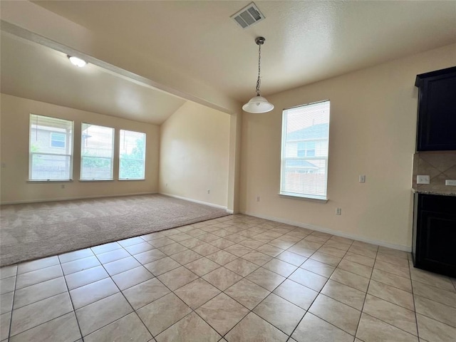 1404 Elbe St, Pflugerville, TX 78660 - unfurnished dining area featuring plenty of natural light, light tile patterned floors, light colored carpet, and lofted ceiling