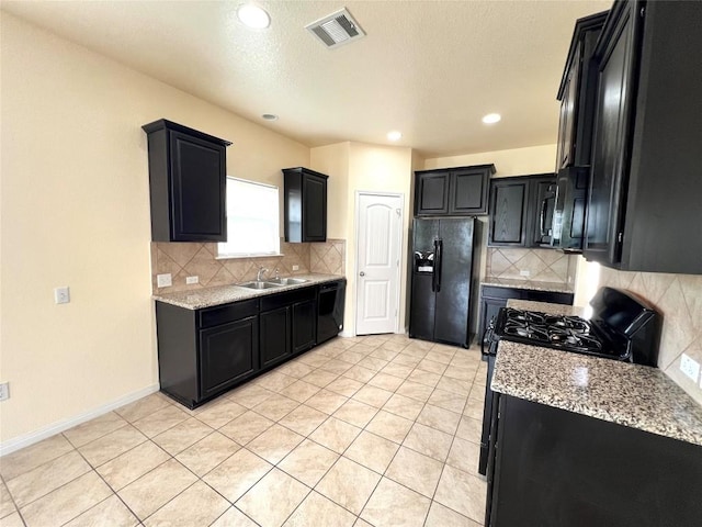 1404 Elbe St, Pflugerville, TX 78660 - kitchen featuring black appliances, dark cabinets, light stone counters, tasteful backsplash, and recessed lighting