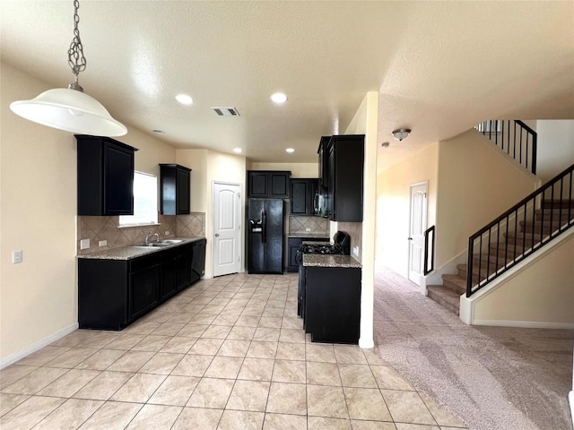 1404 Elbe St, Pflugerville, TX 78660 - kitchen featuring black fridge, dark cabinetry, backsplash, light tile patterned floors, and light stone counters