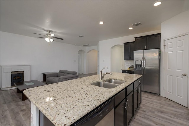 kitchen featuring a sink, ceiling fan, visible vents, arched walkways, and appliances with stainless steel finishes