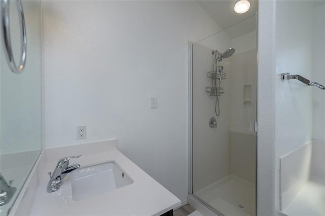 bathroom featuring a stall shower and a sink