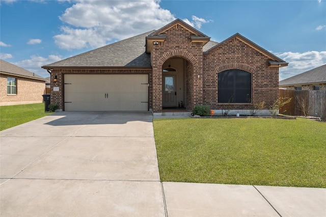 view of front of house with a front yard, a garage, and brick siding