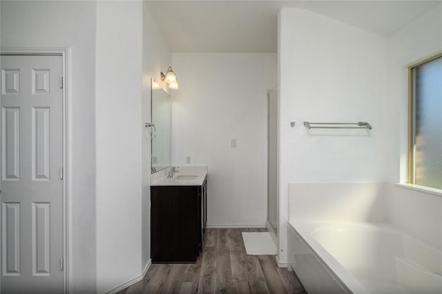 bathroom with a garden tub, vanity, wood finished floors, and a stall shower