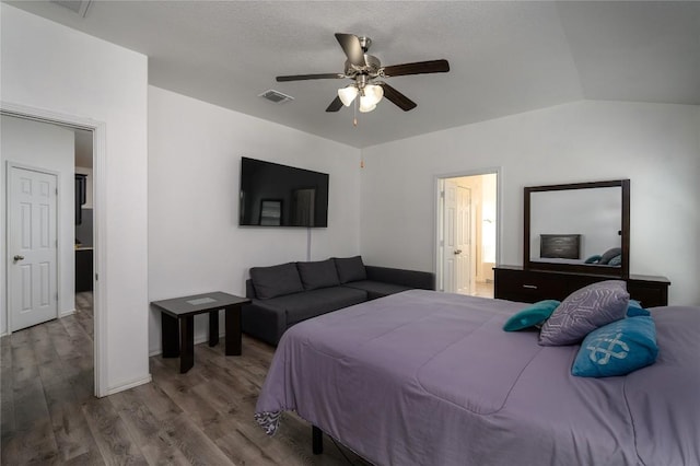 bedroom with connected bathroom, ceiling fan, wood finished floors, visible vents, and lofted ceiling