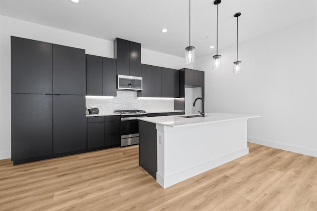 590 Old Mill Rd Unit 113, Cedar Park, TX 78613 - kitchen featuring appliances with stainless steel finishes, a sink, modern cabinets, dark cabinets, and pendant lighting
