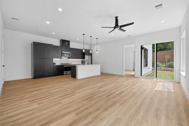 590 Old Mill Rd Unit 113, Cedar Park, TX 78613 - unfurnished living room featuring recessed lighting, baseboards, a ceiling fan, a sink, and light wood-style floors