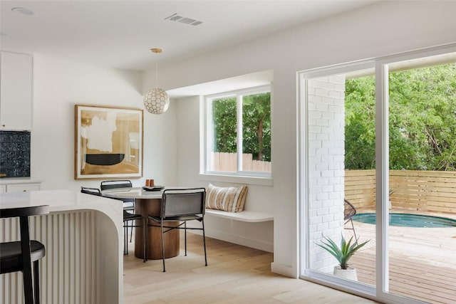 dining space featuring light wood-style floors and visible vents