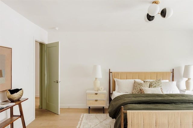 bedroom featuring baseboards and light wood finished floors