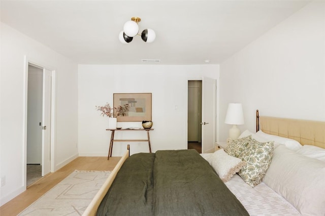 bedroom featuring baseboards, visible vents, and light wood-type flooring