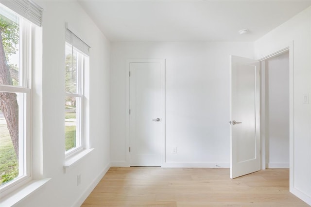 unfurnished bedroom featuring light wood-type flooring and baseboards