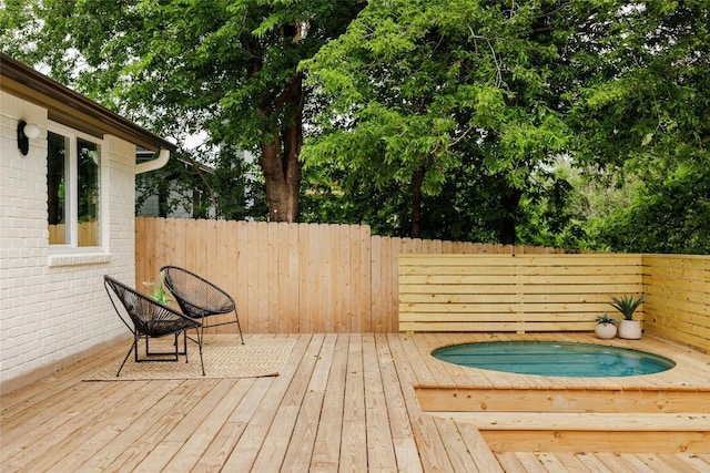 deck featuring a jacuzzi and fence