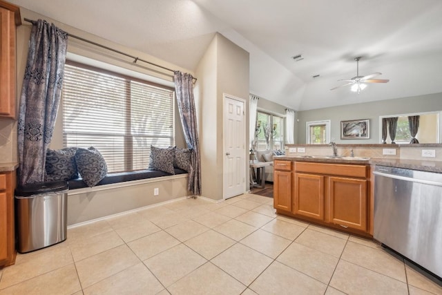 kitchen with brown cabinets, ceiling fan, a sink, lofted ceiling, and stainless steel dishwasher