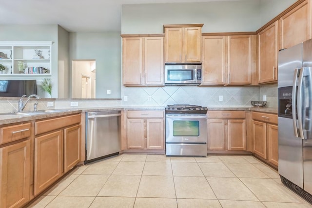 kitchen featuring stainless steel appliances, light tile patterned flooring, a sink, and tasteful backsplash