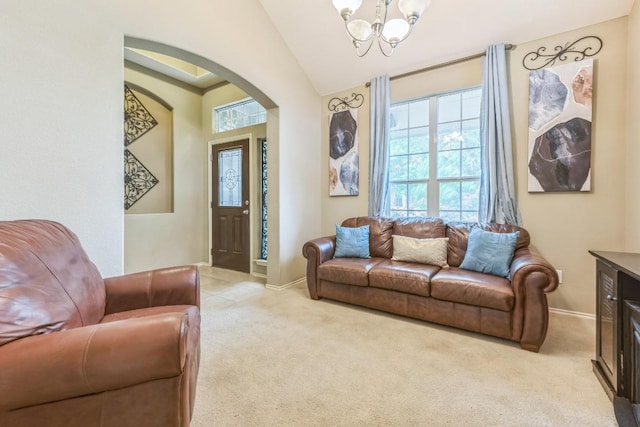 living area with light colored carpet, arched walkways, a chandelier, baseboards, and lofted ceiling