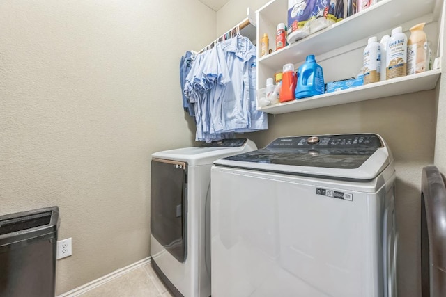 laundry room with washer and dryer, laundry area, baseboards, and tile patterned floors