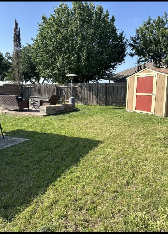 view of yard featuring a storage shed, a patio, an outbuilding, and a fenced backyard