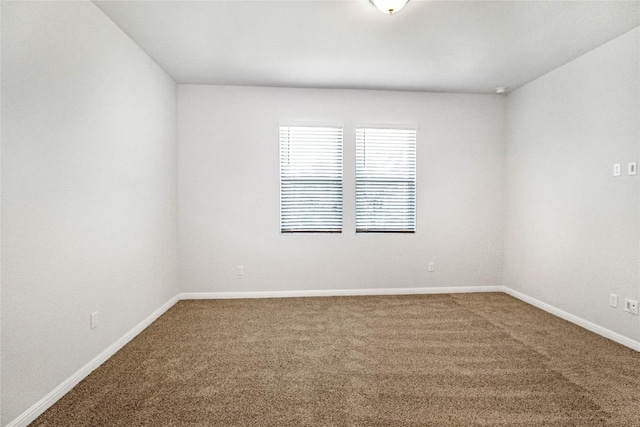 carpeted spare room with baseboards