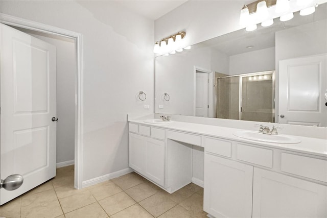 bathroom featuring double vanity, a sink, a stall shower, and tile patterned floors