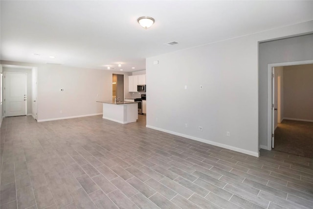 unfurnished living room featuring baseboards, light wood-style flooring, and visible vents