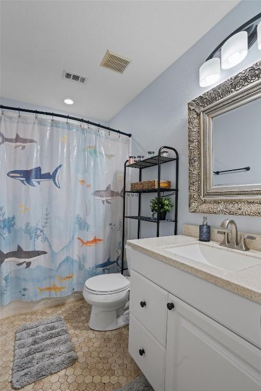full bath featuring toilet, visible vents, curtained shower, and vanity
