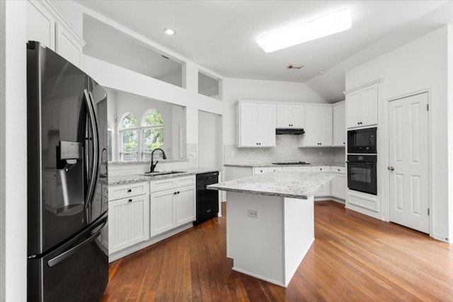 kitchen featuring a sink, white cabinetry, lofted ceiling, under cabinet range hood, and black appliances