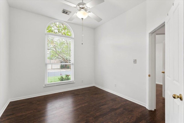 empty room featuring dark wood-style flooring, ceiling fan, visible vents, and a healthy amount of sunlight