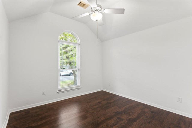 spare room with baseboards, visible vents, dark wood-style floors, and lofted ceiling
