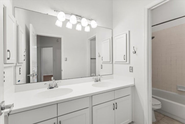 full bathroom featuring a sink, tile patterned floors, toilet, and double vanity
