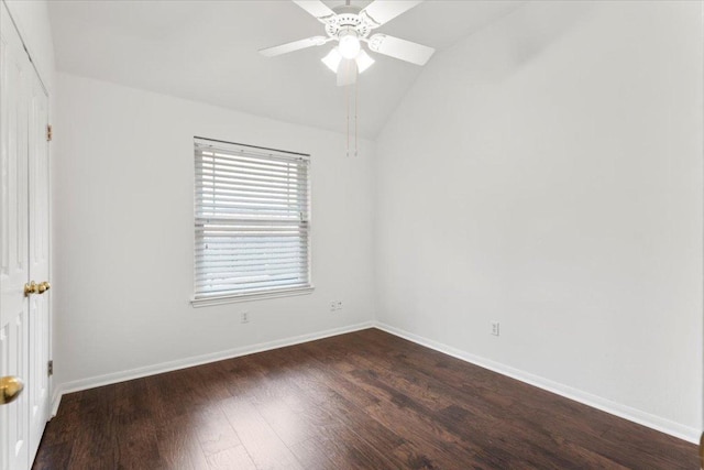 spare room with baseboards, ceiling fan, dark wood-style flooring, and lofted ceiling