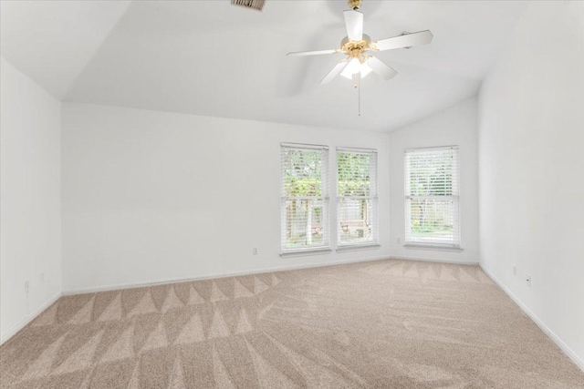 carpeted empty room with baseboards, a ceiling fan, vaulted ceiling, and visible vents