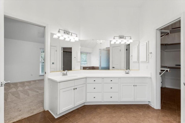 bathroom featuring a sink, tile patterned flooring, double vanity, and a spacious closet