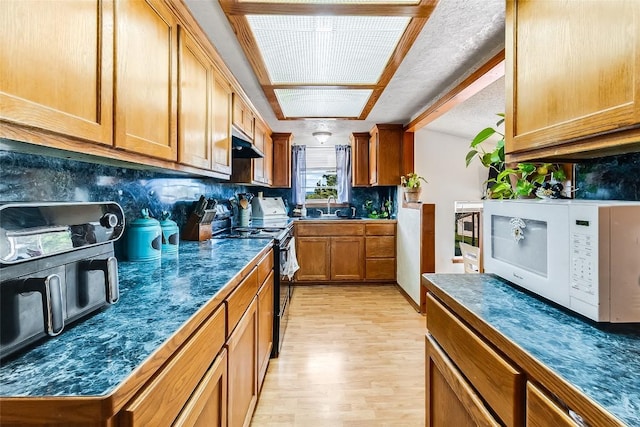 288 Ballard St, Tow, TX 78672 - kitchen featuring under cabinet range hood, dark countertops, black electric range oven, and white microwave