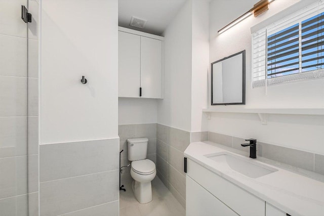 1105 Lipan Trl, Austin, TX 78733 - bathroom featuring tile walls, vanity, tile patterned floors, and a wainscoted wall