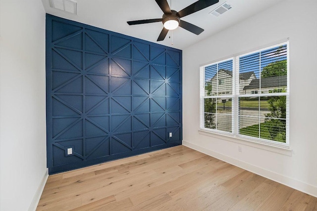 1105 Lipan Trl, Austin, TX 78733 - empty room featuring light wood-style flooring, a decorative wall, and a ceiling fan