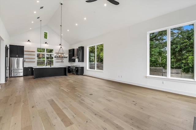 1105 Lipan Trl, Austin, TX 78733 - unfurnished living room featuring healthy amount of natural light, a ceiling fan, light wood-style floors, high vaulted ceiling, and recessed lighting