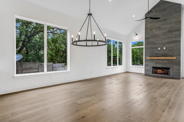 1105 Lipan Trl, Austin, TX 78733 - unfurnished living room featuring healthy amount of natural light, high vaulted ceiling, wood finished floors, a large fireplace, and ceiling fan