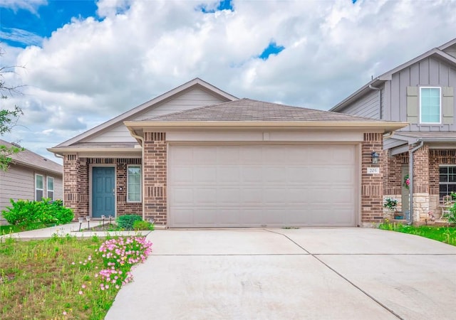 205 Granary Dr, Kyle, TX 78640 - ranch-style house featuring concrete driveway, brick siding, board and batten siding, and a garage
