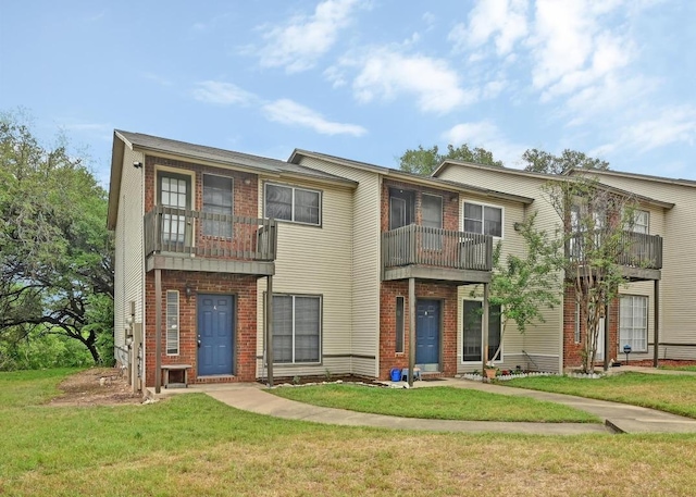 1815 River Crossing Cir Unit A, Austin, TX 78741 - view of property with a front lawn, brick siding, and a balcony