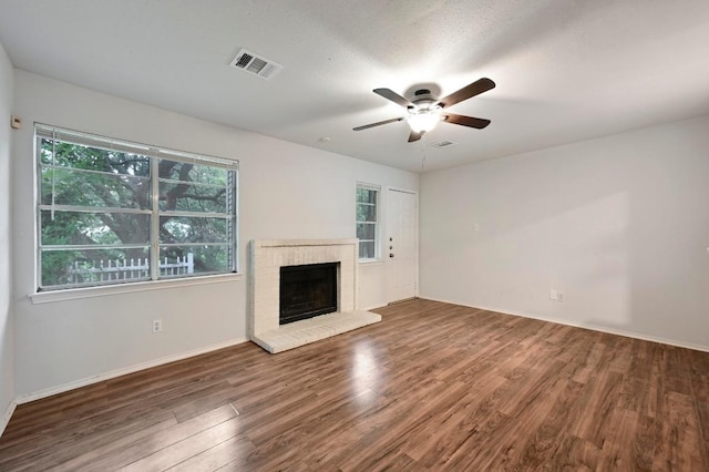1815 River Crossing Cir Unit A, Austin, TX 78741 - unfurnished living room with ceiling fan, wood finished floors, healthy amount of natural light, and a fireplace