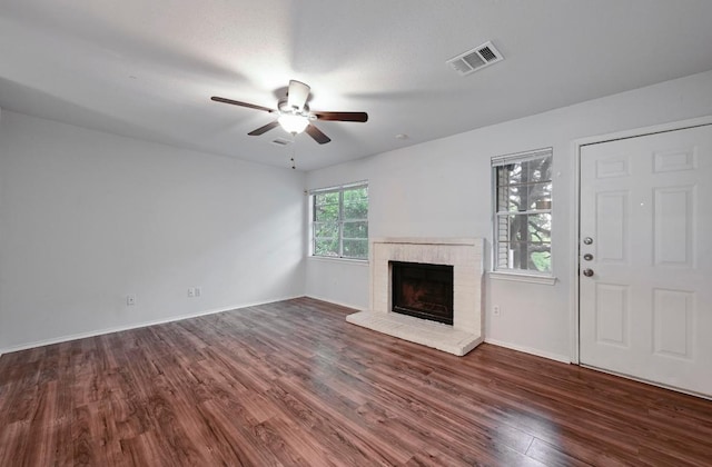 1815 River Crossing Cir Unit A, Austin, TX 78741 - unfurnished living room featuring wood finished floors, a ceiling fan, a brick fireplace, and baseboards