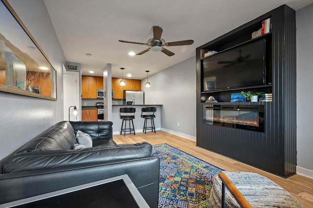 1115 W 10th St Unit 100, Austin, TX 78703 - living area featuring a ceiling fan, a glass covered fireplace, light wood finished floors, baseboards, and recessed lighting